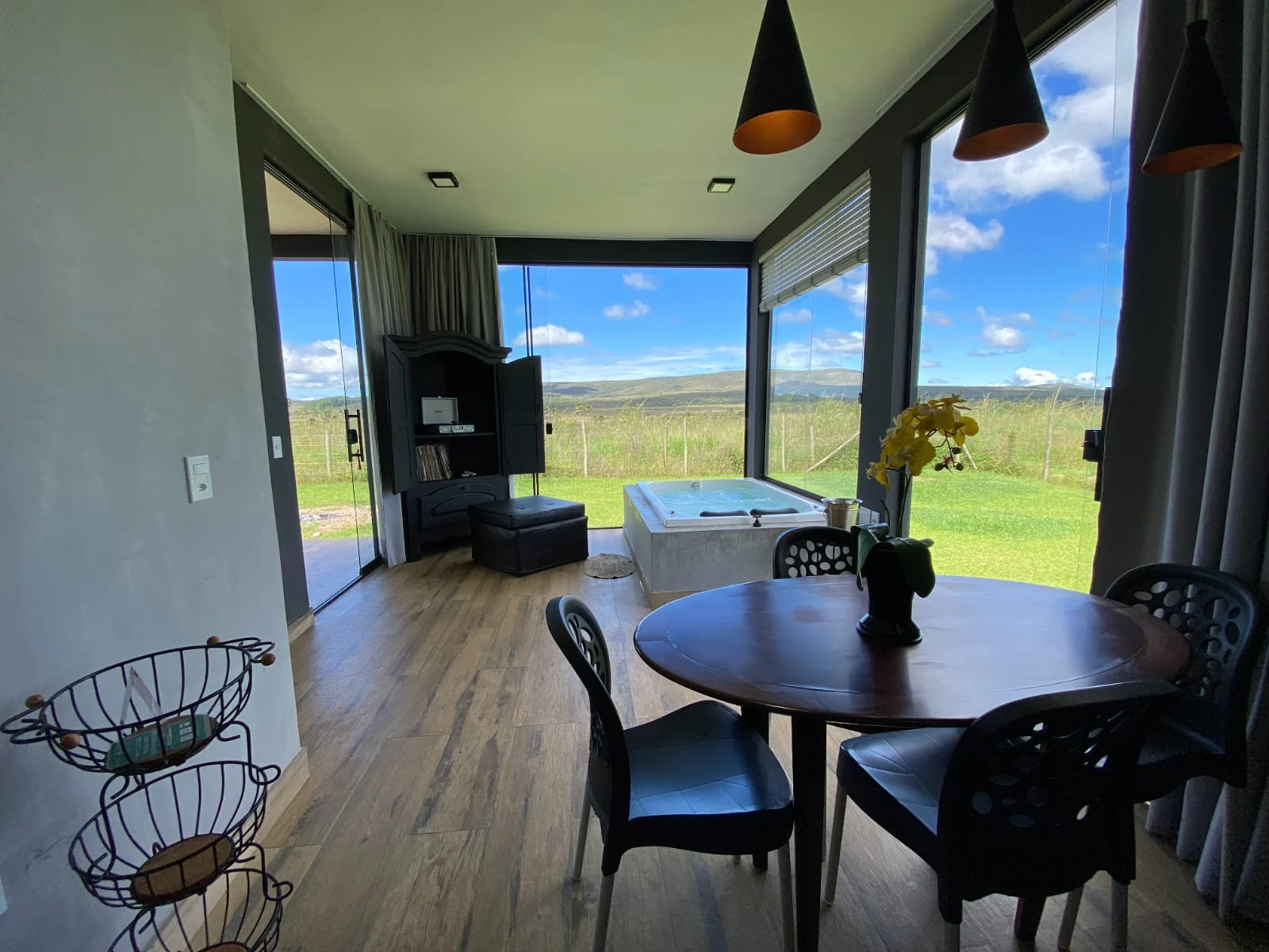 Sala com mesa de jantar e hidromassagem junto ao vidro